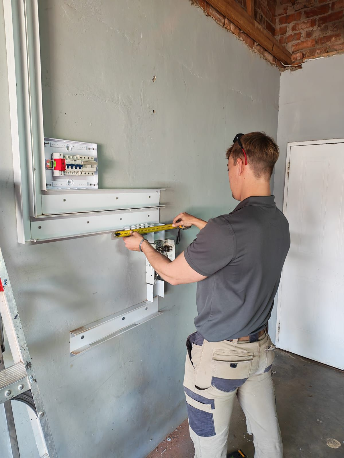 Technician measuring electrical installation during setup